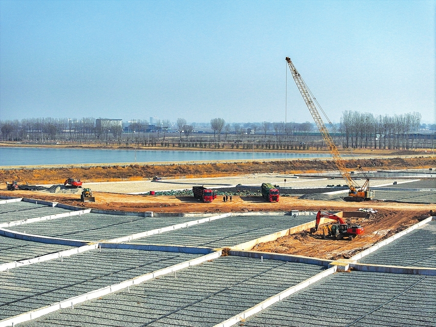 工人在平遥县惠济河垂直流人工湿地水质净化工程工地装填滤石