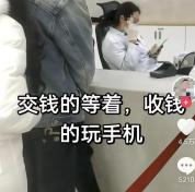 医院收费员玩手机多人排队待缴费 窗口冷漠引争议