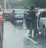 一男子下车后气呼呼地扔掉了前车放置的三角锥