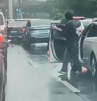 一男子下車后氣呼呼地扔掉了前車放置的三角錐
