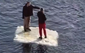 俄罗斯两男子随着浮冰在河面漂流悠闲抽烟闲聊