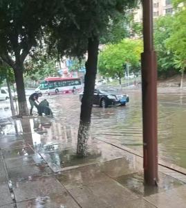 大连急雨中的“最美弯腰” 公交人员紧急排涝