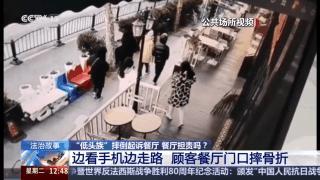 女子看手机餐厅前摔骨折谁该担责
