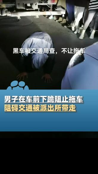 男子在车前下跪阻止拖车