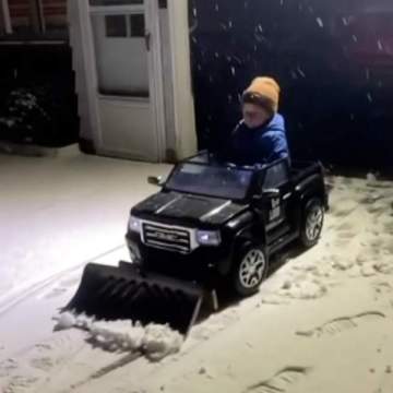Little boy helps dad plow snow with toy car