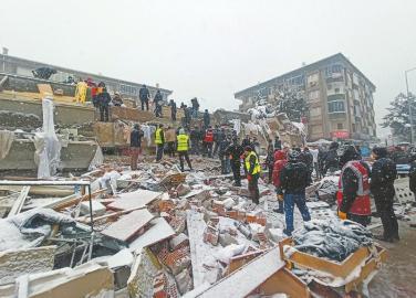 2月6日，人们在土耳其马拉蒂亚一处倒塌的建筑上搜救。 新华社发