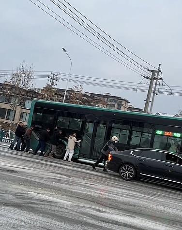 公交车雪中打滑 乘客集体推车 陌生肩膀汇聚暖流