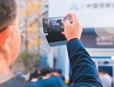 二〇二三中国视听创新大会的主会场外，观众用手机摄影留念。　　主办方供图