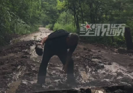女司机进退两难陌生 大叔徒手帮清污泥