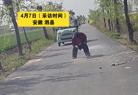 大姐用外套清扫事故现场碎玻璃