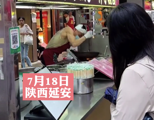 摊主猛抡铁锅做搅团,不断用力敲打铁锅看傻顾客