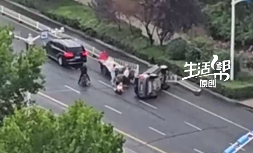 众人冒雨抬起侧翻汽车 拍摄者：还是好心人多！