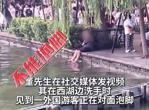 西湖回应网友曝外国游客湖边泡脚：西湖边不建议玩水