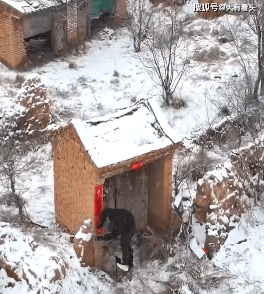 男子冒雪回老家贴春联 落叶归根的思念