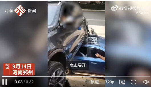 女子倒车不当悬空压在路边车顶