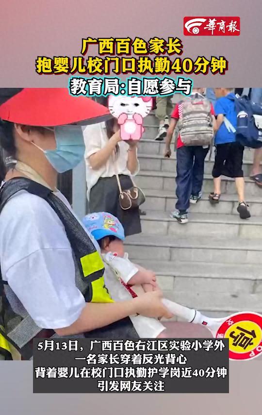 家長(zhǎng)背嬰兒在校門口執(zhí)勤