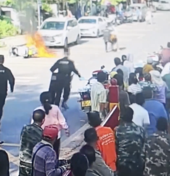女子骑摩托车摔倒身上起火 警民合力扑救