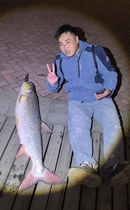 男子钓到超大鱼骑电动车满街“晒快乐”