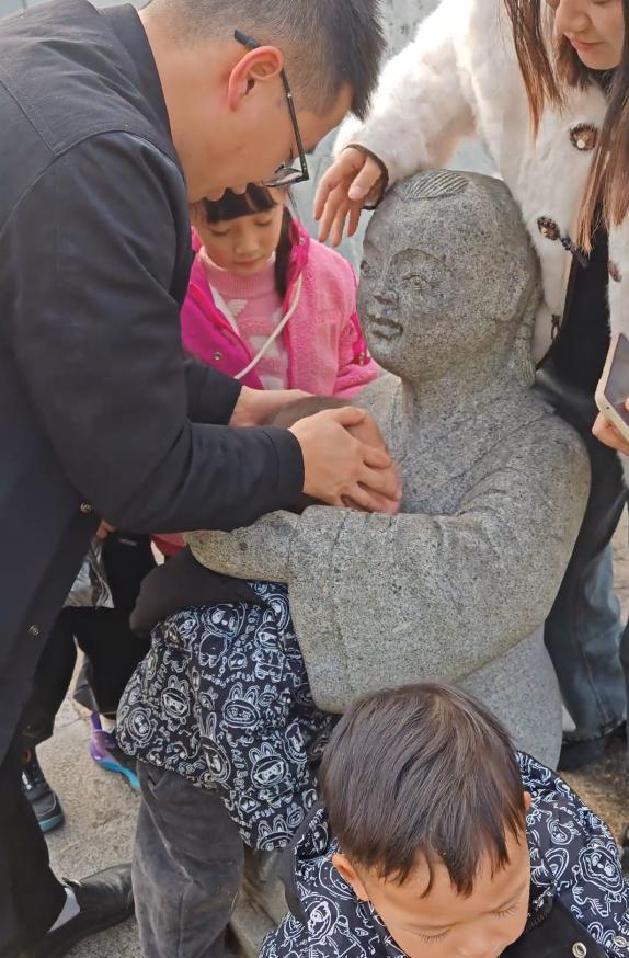 小孩一头扎进石像怀里出不来 家长回应:评论区笑不活了!