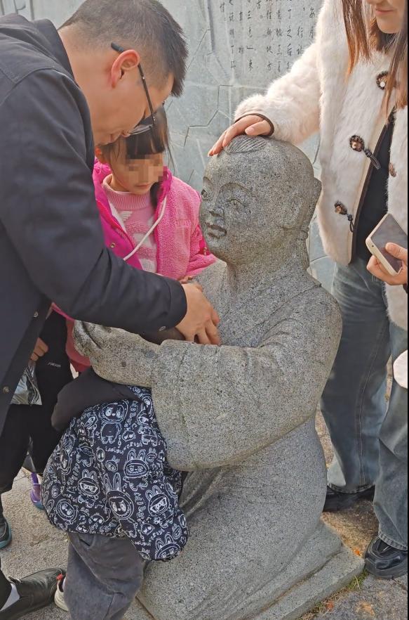 小孩一头扎进石像怀里出不来 家长回应:评论区笑不活了!