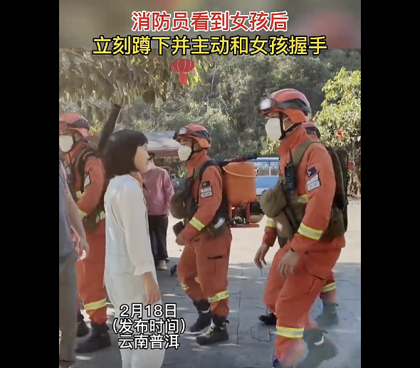 消防主动蹲下同女孩握手