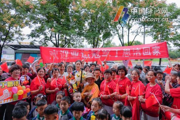 连获三枚金牌的丁思洁回家啦!小区阿姨敲锣打鼓送鲜花,丁思洁:有点社恐