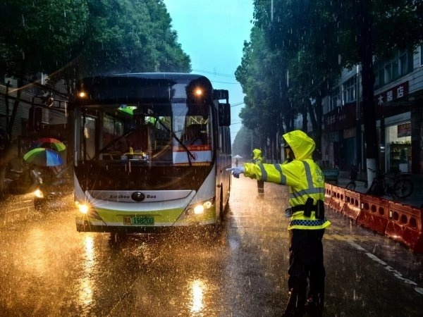 暴雨中光脚执勤的交警祝福考生 风雨中的“警”色
