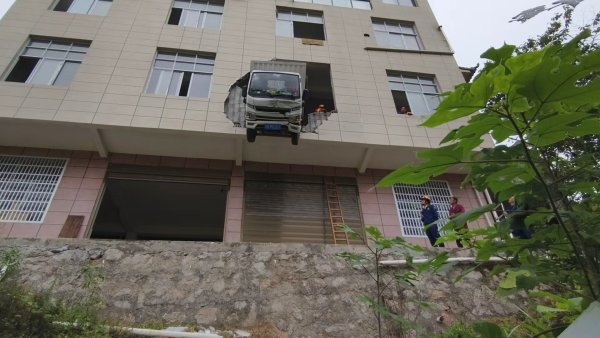 货车冲出二楼悬在15米高半空 司机惊魂获救