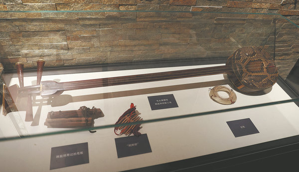 A replica of the sanxian given as a gift by Chairman Mao Zedong to Shaanbei storyteller Han Qixiang and other musical instruments used in performances on display in the Yan'an Quyi Performance Theater museum. [Photo by ZOU HONG/CHINA DAILY]