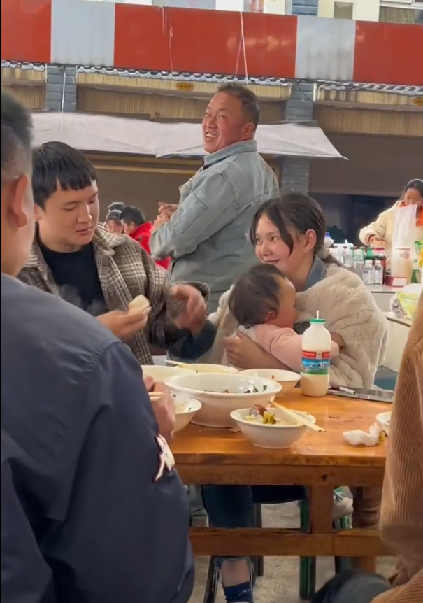 丈夫给抱孩子妻子喂饭