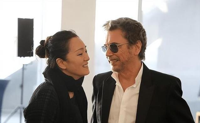59岁巩俐机场甜靠老公，笑容满面像少女，76岁米歇尔却帅如壮年
