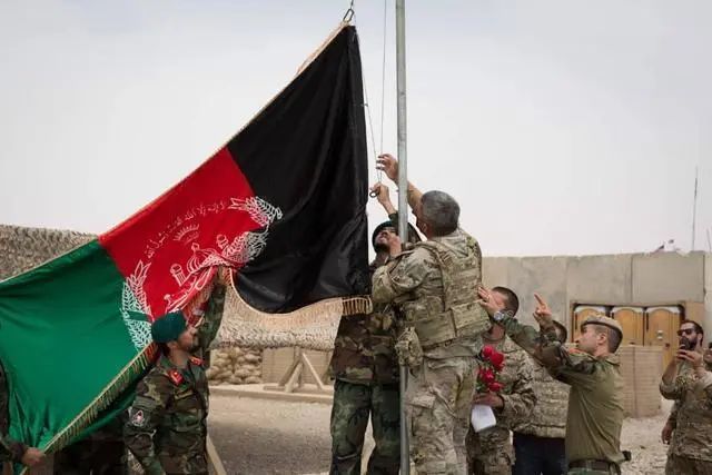 ▲资料图。5月2日，阿富汗士兵与美军士兵在阿富汗赫尔曼德省一处军事基地升起阿富汗国旗。当日，美军向阿富汗国民军移交这处军事基地。图片来源：新华社。