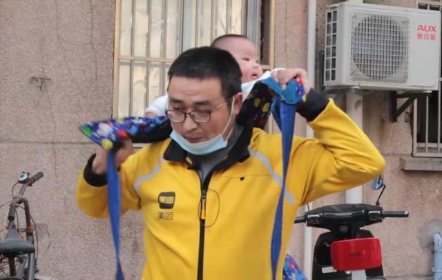 外卖小哥背1岁孩子送餐：不敢交给孩子妈妈