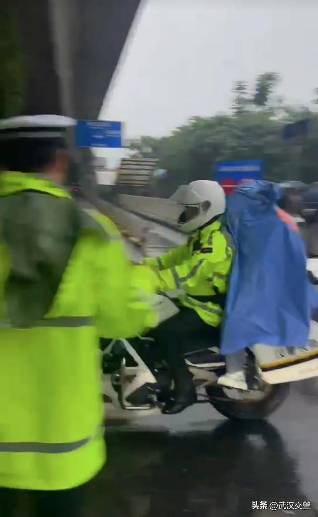 交警在大雨中为高考生撑伞 风雨无阻护考路