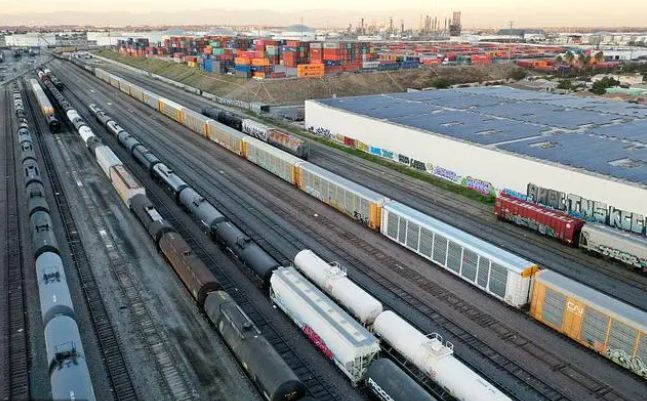 当地时间2022年11月22日，美国威尔明顿，货运列车停在集装箱附近的铁路场里 图源：视觉中国