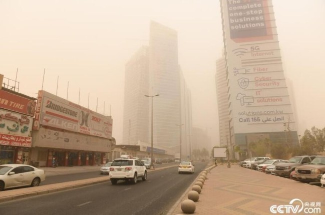 央视网消息：当地时间6月17日，在科威特首都科威特城，建筑物笼罩在沙尘中。当日，科威特城遭遇沙尘暴天气。人民视觉