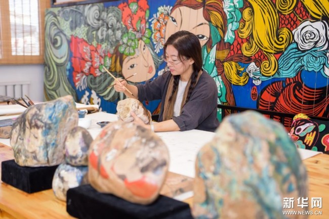 8月26日，在位于内蒙古乌海市海南区黄河西行客栈的工作室内，鲁婷在进行黄河石彩绘创作。