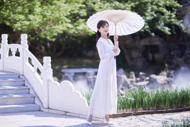 68岁赵雅芝穿白裙优雅迷人 撑油纸伞漫步桥上