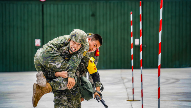 比武人员背起“伤员”向终点奋力冲锋。