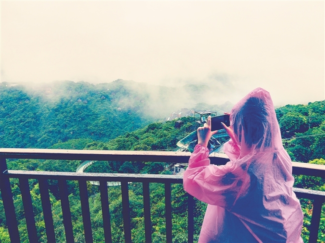亚龙湾热带天堂森林公园呈现云雾缭绕、如梦如幻的景象，吸引景区游客驻足观看，拍照留影。本报记者 武威 摄