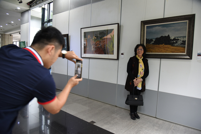 Painter Ding Mengfang poses in front of his work. Photo by Xu Ersheng