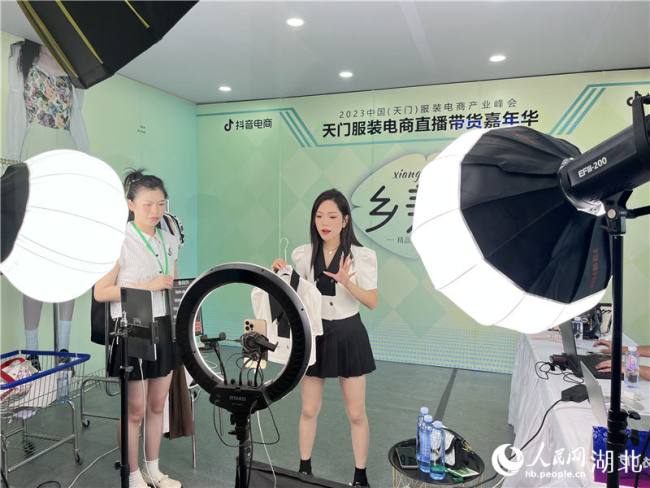 直播间主播正在向网友展示衣服。人民网记者 张隽摄