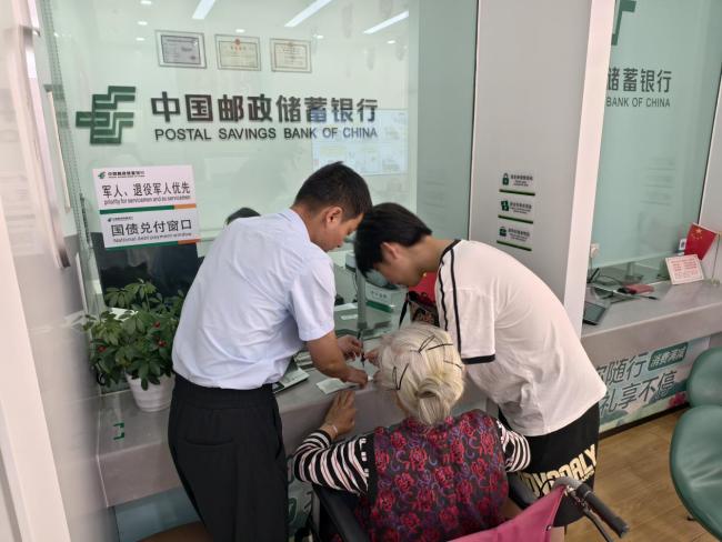 轮椅上的“金融温度” 邮储银行英山县支行营业部真情服务暖人心