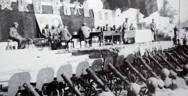 上图_ 志愿军某部入朝前誓师大会，台前摆放着迫击炮、重机枪