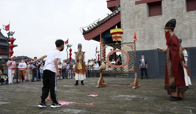 西安城墙上举办“大唐运动会” 游客体验蹴鞠游戏