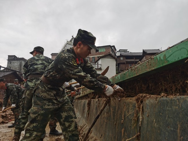 6月20日，武警官兵正在清理淤泥。 侯鲁晋 摄