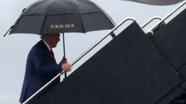 特朗普自己撑着伞，说这是“悲伤的一天”