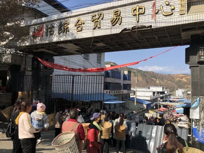 2月26日，泸沽综合贸易中心门前，乘5633次列车前来的彝族老乡排队进入市场采购。新京报记者 韩沁珂 摄