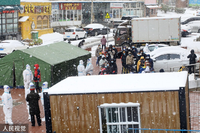 2021年11月8日，辽宁大连，沙河口区马栏街道兰青社区居民冒雪排队等待核酸采样。