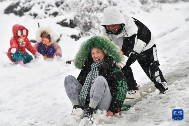 12月26日，在湖南省湘西土家族苗族自治州花垣县，人们在雪中玩耍。